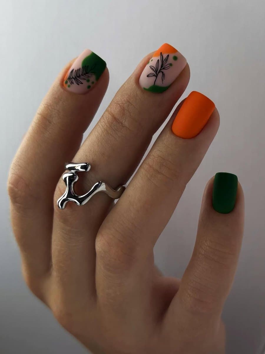 Hand-painted abstract nail art in green and amber tones.